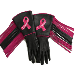 A pair of gloves with pink ribbon and fringe.