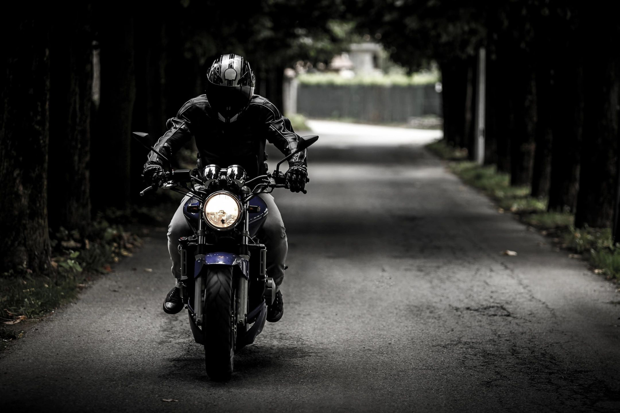 A person on a motorcycle riding down the street.